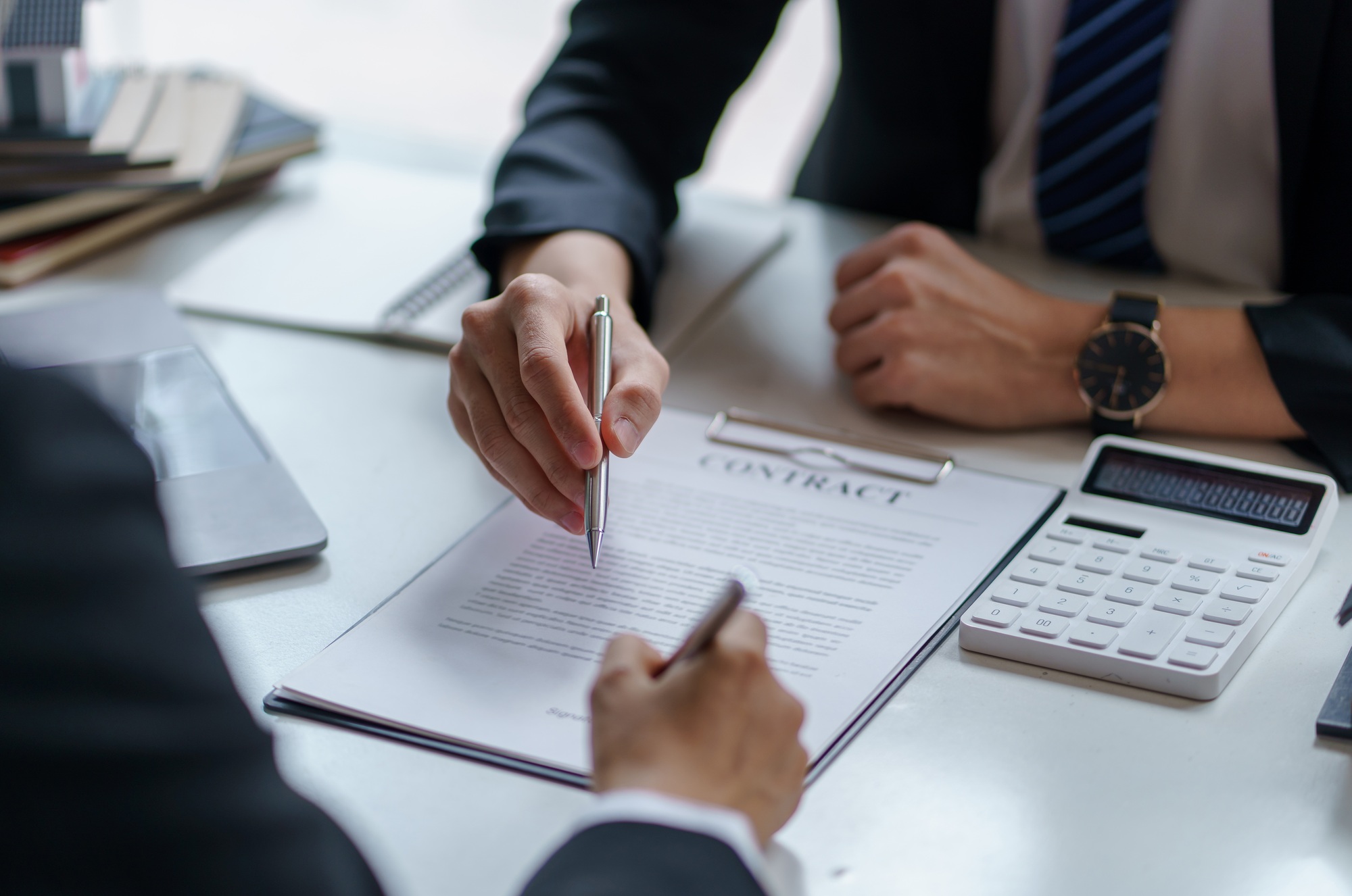 Close-up of business people discussing and signing a business contract
